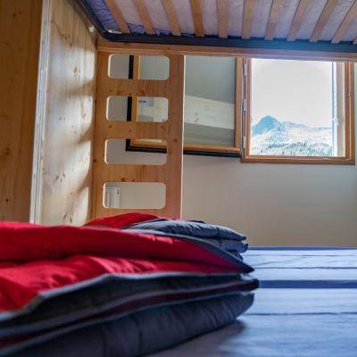 Intérieur d'un dortoir du refuge avec vue sur la montagne - construction du refuge par l'architecte Nathalie Ott de l'Atelier Ott